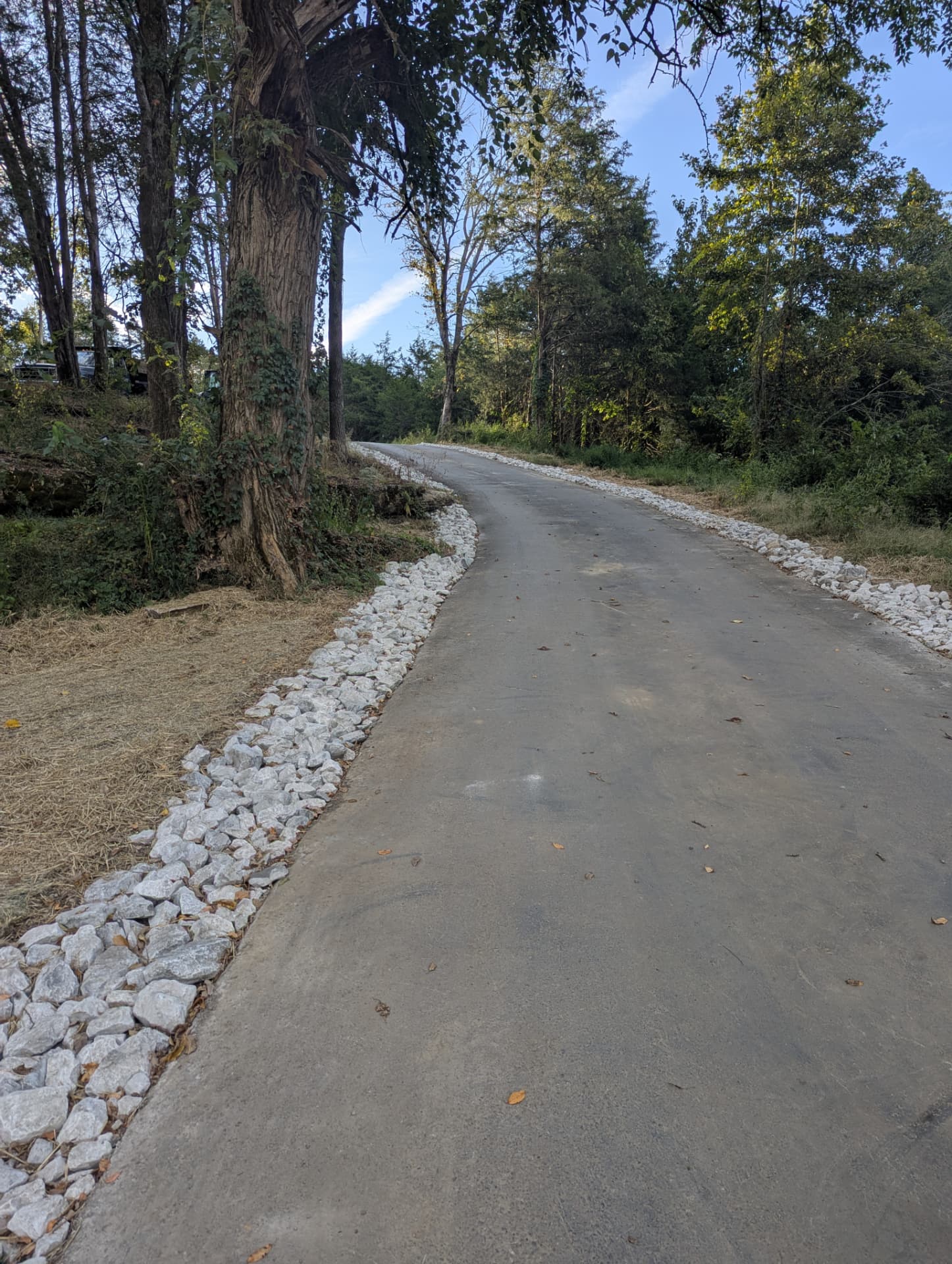 Riprap drainage along both sides of a paved residential driveway