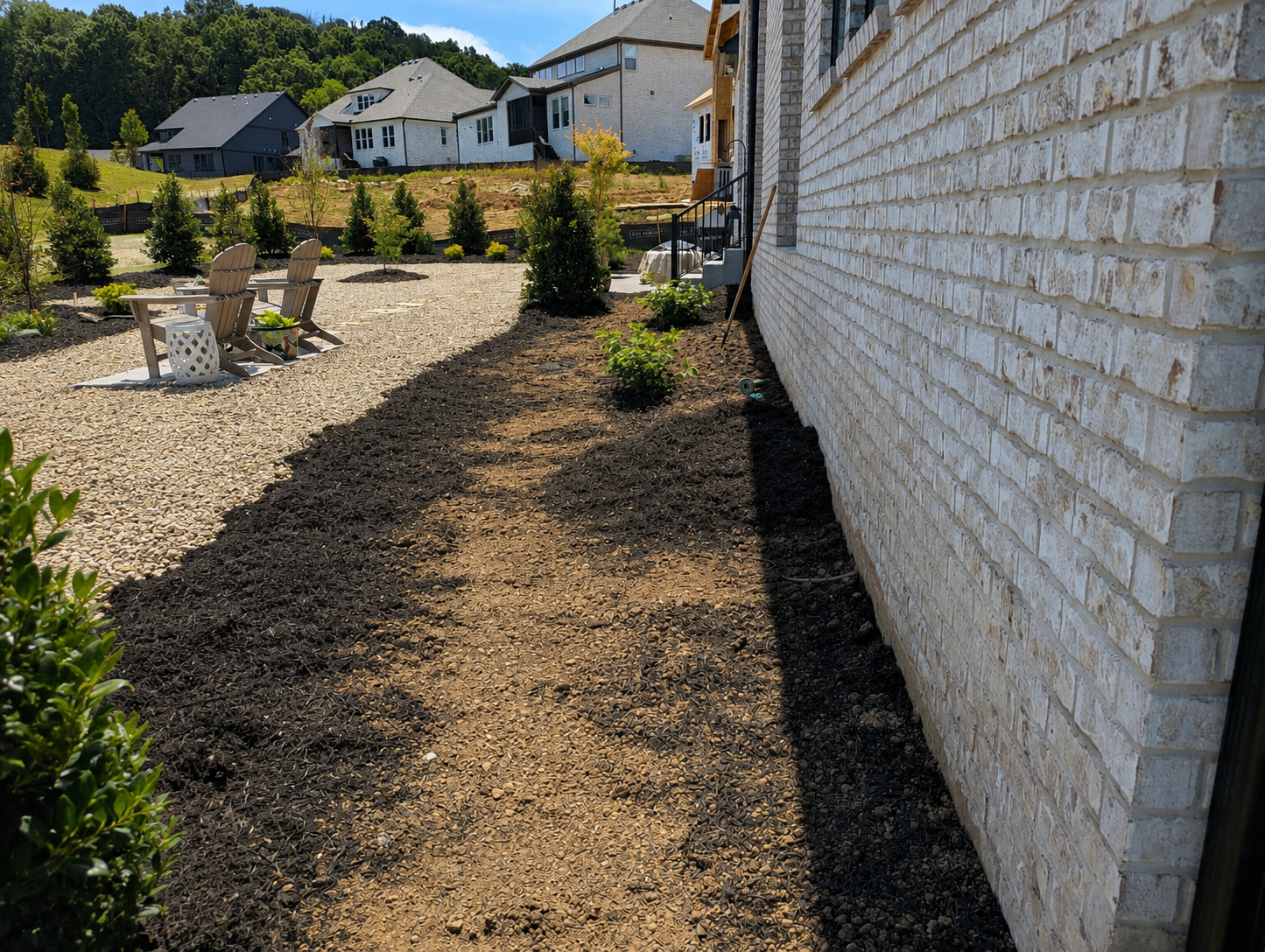 Finish grading along the side of a Franklin TN home in the Starnes Creek subdivision showing positive slope away from the foundation
