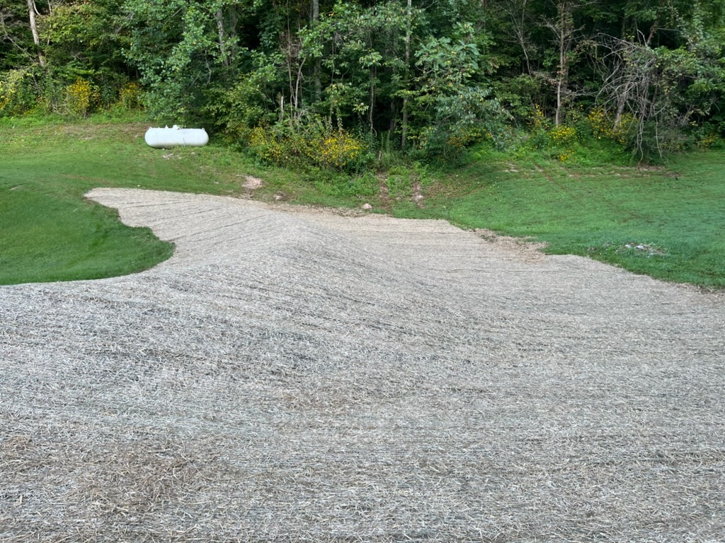 Finished seed and erosion blanket over a newly shaped drainage berm and spillway area in Columbia, TN.