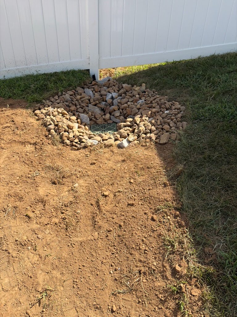 Completed stormwater catch basin protected with riprap and drainage stone