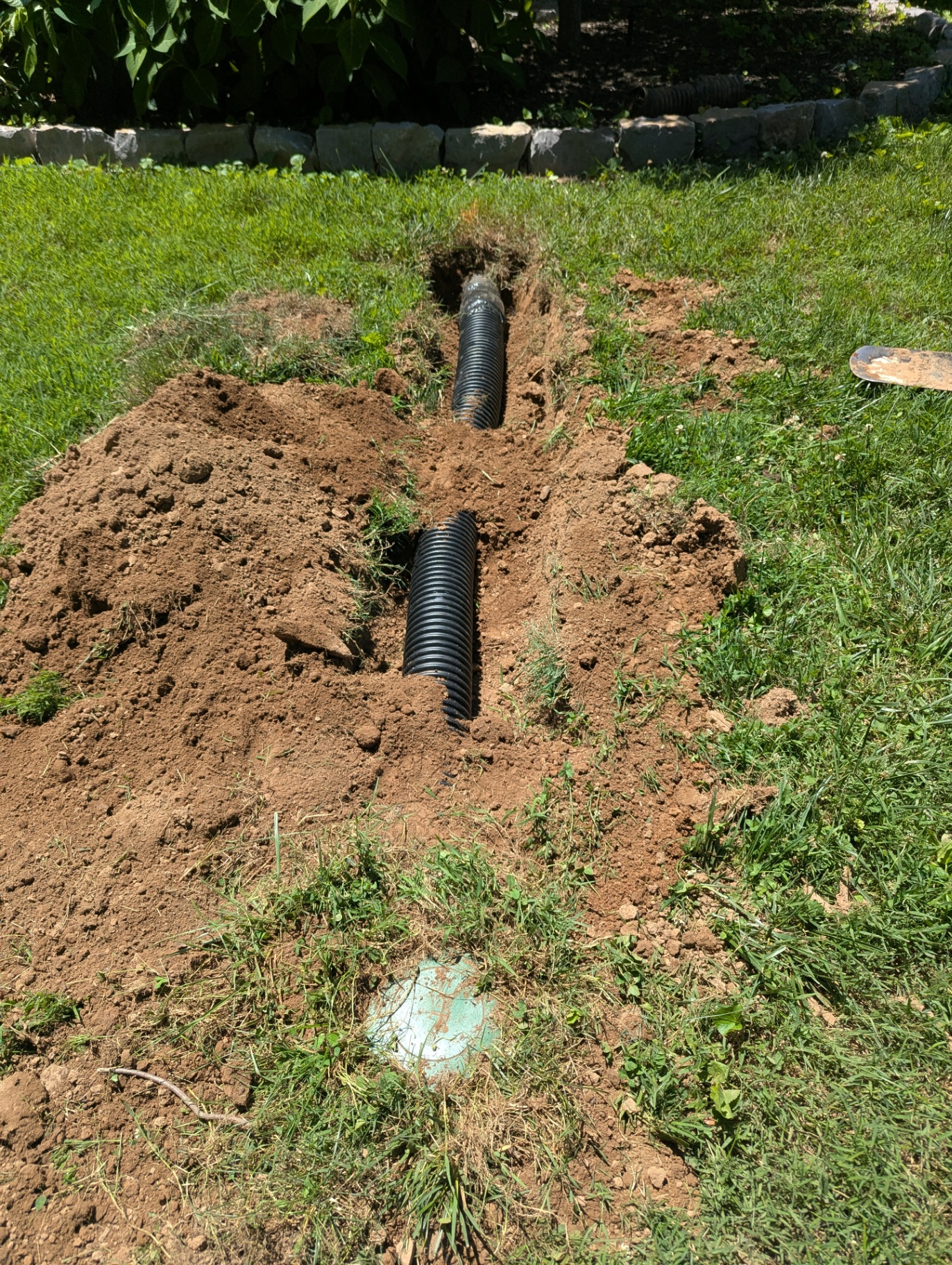 New buried solid drain pipe installed to carry downspout runoff away from a Williamson County home