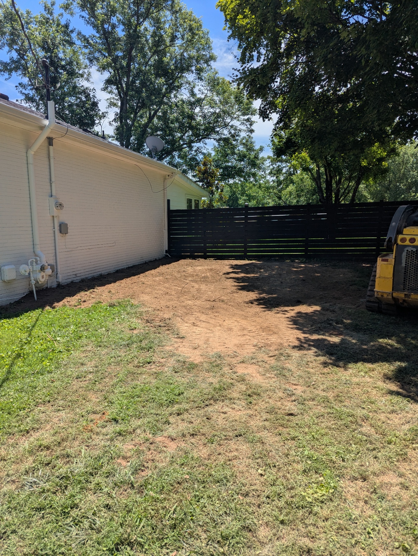 Completed positive yard grading along the side of a home in Williamson County, TN by CANDO LLC